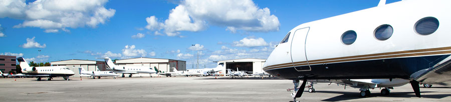 Private jets parked on the airfield.