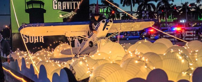 Boca Raton Holiday Parade BRAA float Defying Gravity shows witch on top of Cessna 172