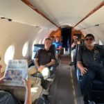 Students seated inside private jet at Signature Flight Support hangar