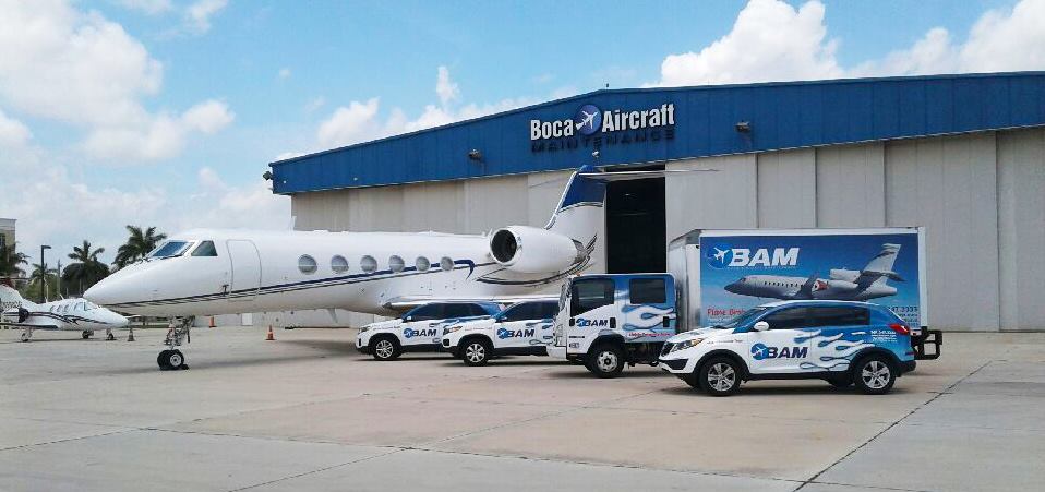 Hangar with some cars and airplane in front