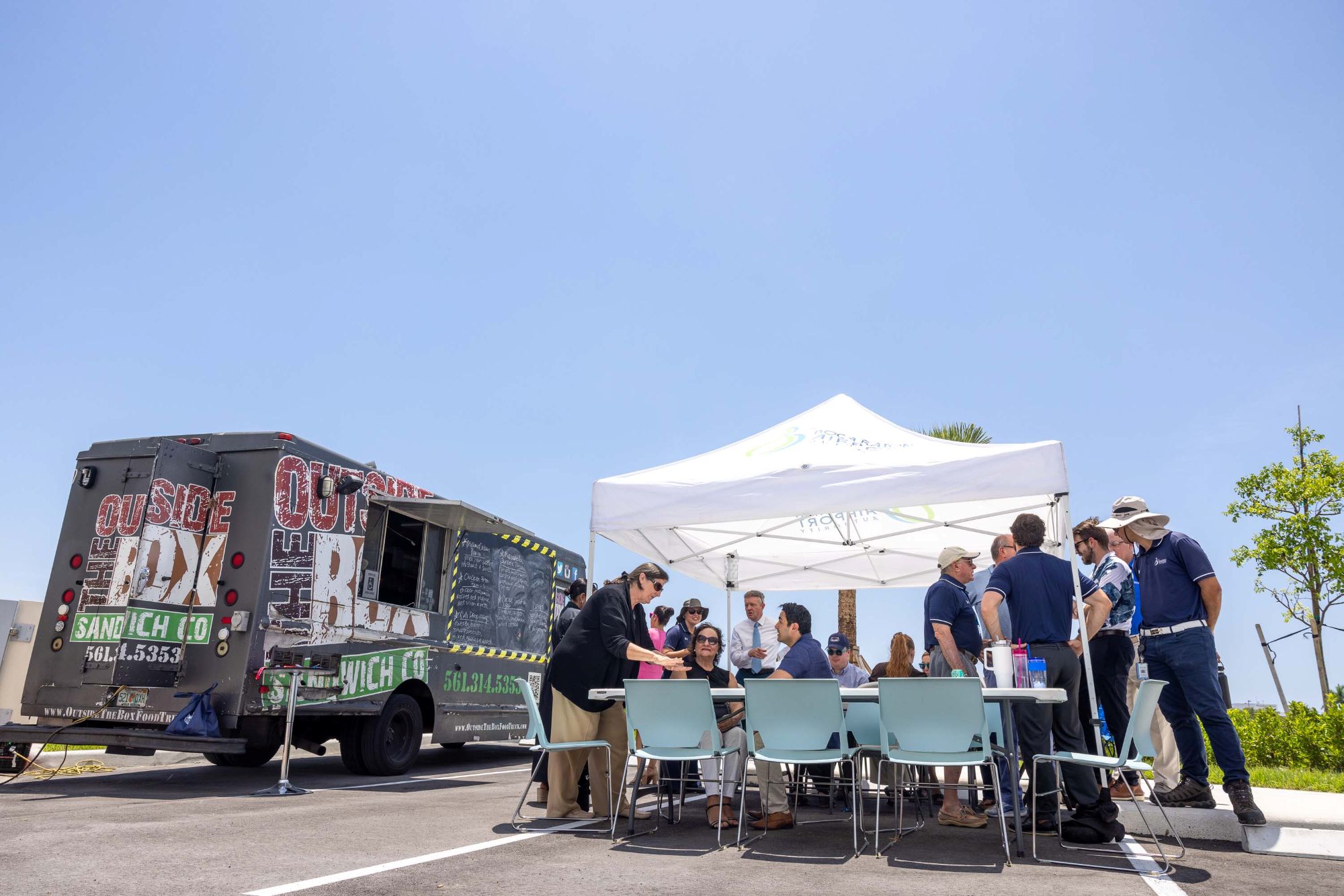 People under a tent next to a food truck
