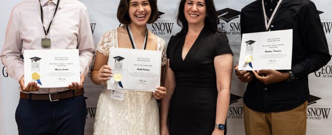 4 people standing in front of a photo wall for The George Snow Scholarship